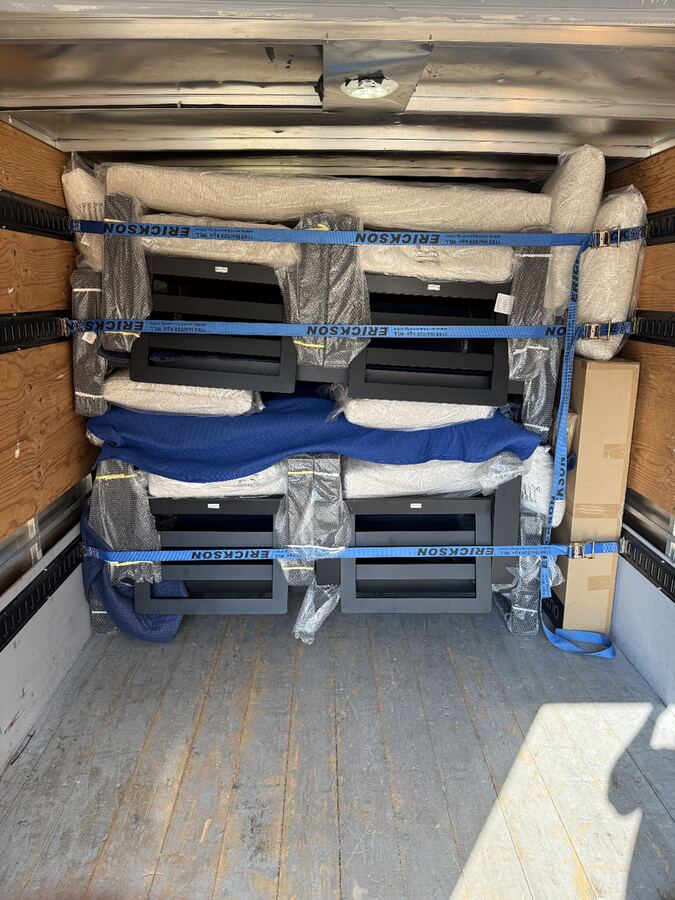 Box truck loaded with wrapped furniture strapped in for delivery