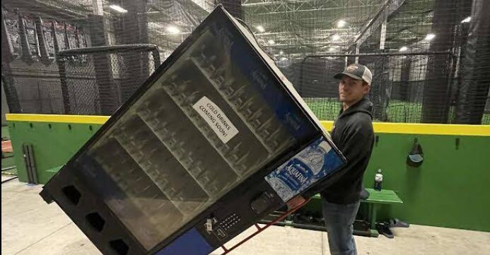 Mover wheeling a vending machine on a dolly